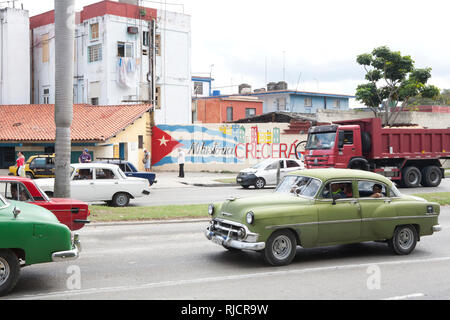 Traffic on a road in Havana cuba with cuban flag painted on a wall Stock Photo