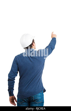 Rear view of young man engineer wearing protective helmet pointing finger up like pressing an imaginative button isolated over white background with c Stock Photo