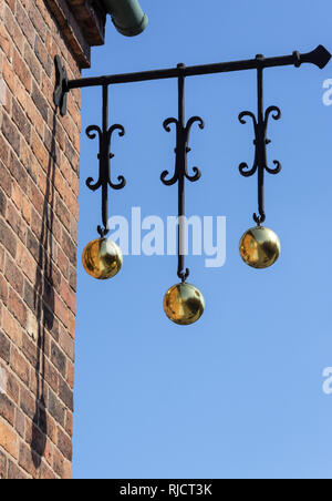 The traditional sign of a pawn shop which dates back to when most people were unable to read or write and relied on symbols to identify shops Stock Photo