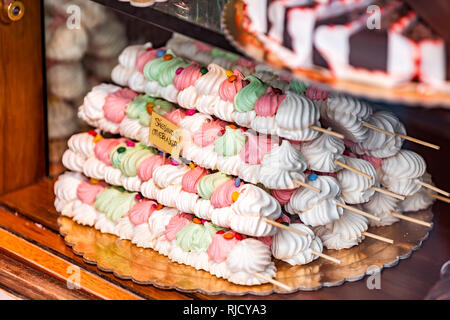 Small colorful green red and pink baked egg meringue closeup in store window in Italy dessert on display in gourmet bakery Italian cafe with sign Stock Photo