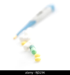 Isolated Digital Thermometer with pills on white background Stock Photo