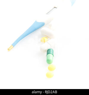 Isolated Digital Thermometer with pills on white background Stock Photo