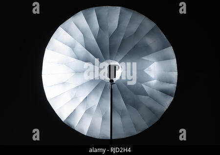 Convex or concave? Optical illusion created by light  and big parabolic light shaper tool in photography studio. Stock Photo
