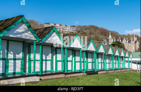 Swansea, South Wales UK 02/02/2019 Beach huts in Langland Bay, The Mumbles, Gower, South Wales, with the old hotel nestling in the trees behind. Stock Photo