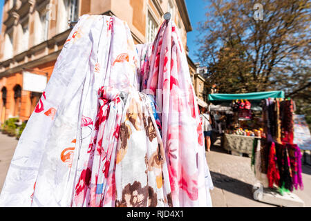 Closeup pattern of many summer scarves colorful vibrant colors hanging on display in shopping street market in Warsaw, Poland Stock Photo