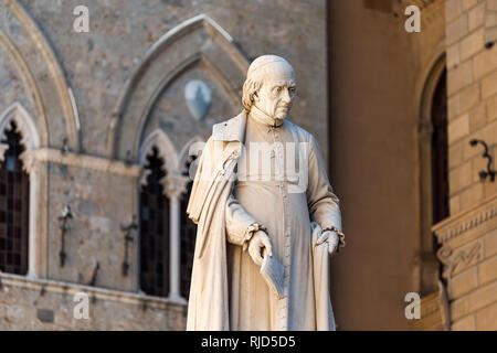 Siena, Italy - August 27, 2018: Historic medieval old town village in Tuscany with statue in Palazzo Salimbeni Stock Photo