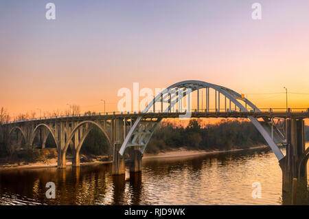The sun sets behind the Edmund Pettus Bridge, Feb. 14, 2015, in Selma, Alabama. The bridge played an important role in the Civil Rights Movement. Stock Photo