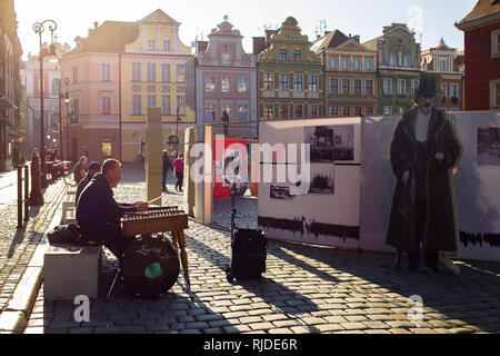 Old Town Square in Poznan remembers national hero Ignacy Paderewski while nearby an artist is playing on hammered dulcimer Stock Photo