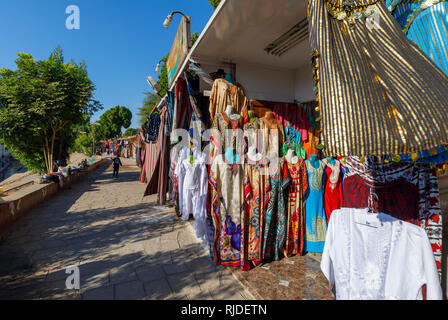 Market on the banks of the Nile by the Temple of Kom Ombo, Upper Egypt selling traditional colourful galabeyas as souvenirs for tourists from cruises Stock Photo