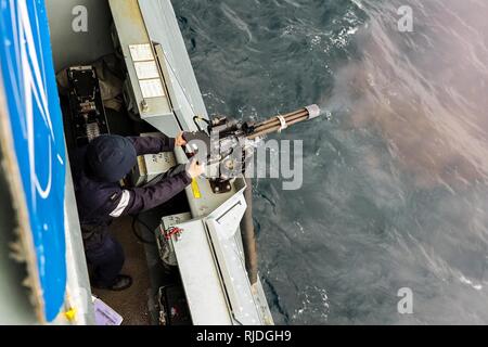 MEDITERRANEAN SEA (January 19, 2018) A sailor aboard Standing NATO Maritime Group Two (SNMG2) flagship, Royal Navy destroyer HMS Duncan, conducts small arms training at sea with a minigun as part of the upper deck weapons team. SNMG2 is one of four NATO multi-national maritime groups on constant patrol, ready to support NATO requirements. NATO Stock Photo