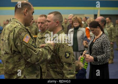 Maj. Gen. Andrew Poppas, 101st Airborne Division (Air Assault) commanding general, pins the Soldier’s Medal on Staff Sgt. Nicholas Davis, C Battery, 1st Battalion, 320th Field Artillery Regiment, 101st Abn. Div. (AASLT) Artillery cannon crew member and section chief, during a ceremony held at Fort Campbell, Jan. 22.  Davis, an Ellijay, Georgia, native and seven-year combat veteran with deployments to Iraq and Afghanistan, received the award for heroism and his lifesaving actions when he rescued a couple from a burning vehicle, June 9, 2017. Stock Photo