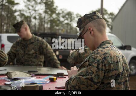 Marines in an Assaultman Course with Infantry Training Battalion, School of Infantry East, build an oval charge at ETA-8A engineer demolition training range and urban breaching facility on Marine Corps Base Camp Lejeune, N.C., Jan. 12, 2018. The exercise was held to demonstrate different demolition and explosive breaching training techniques, and to develop proficiency in mobility support for infantry units. Stock Photo