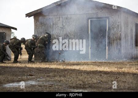 Marines in an Assaultman Course with the Infantry Training Battalion, School of Infantry East, detonate an explosive at ETA-8A engineer demolition training range and urban breaching facility on Marine Corps Base Camp Lejeune, N.C., Jan. 12, 2018. The exercise was held to demonstrate different demolition and explosive breaching training techniques, and to develop proficiency in mobility support for infantry units. Stock Photo