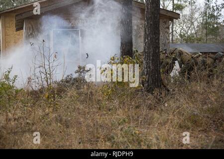 Marines in an Assaultman Course with the Infantry Training Battalion, School of Infantry East, detonate an explosive at ETA-8A engineer demolition training range and urban breaching facility on Marine Corps Base Camp Lejeune, N.C., Jan. 12, 2018. The exercise was held to demonstrate different demolition and explosive breaching training techniques, and to develop proficiency in mobility support for infantry units. Stock Photo