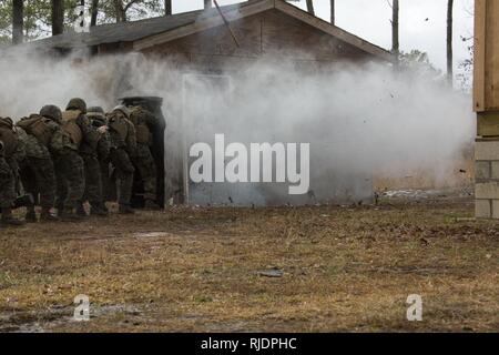 Marines in an Assaultman Course with the Infantry Training Battalion, School of Infantry East, detonate an explosive at ETA-8A engineer demolition training range and urban breaching facility on Marine Corps Base Camp Lejeune, N.C., Jan. 12, 2018. The exercise was held to demonstrate different demolition and explosive breaching training techniques, and to develop proficiency in mobility support for infantry units. Stock Photo