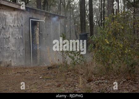 Marines in an Assaultman Course with the Infantry Training Battalion, School of Infantry East, detonate an explosive at ETA-8A engineer demolition training range and urban breaching facility on Marine Corps Base Camp Lejeune, N.C., Jan. 12, 2018. The exercise was held to demonstrate different demolition and explosive breaching training techniques, and to develop proficiency in mobility support for infantry units. Stock Photo