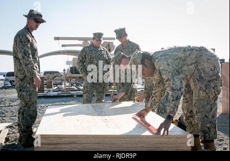 FUJAIRAH, United Arab Emirates (Jan. 13, 2018) Seabees, assigned attached to Amphibious Construction Battalion 1, measure lumber during Native Fury 18. The exercise is designed to train Special Purpose Marine-Air-Ground Task Force-Native Fury Marines and U.S. Navy Sailors in maritime prepositioning force operations and aims to increase proficiency, expand levels of cooperation, enhance maritime capabilities, and promote long-term regional stability and interoperability between the United Arab Emirates and the U.S. Stock Photo