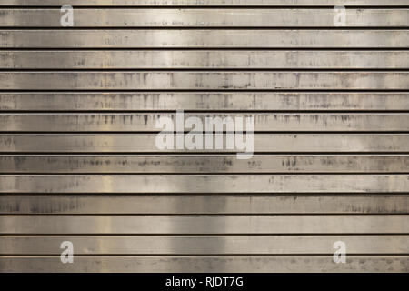 grunge scratched and stained metal roll up door background with horizontal slats Stock Photo