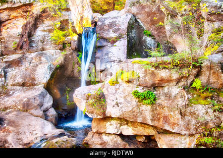 A small waterfall and pools of water at Kent Falls State Park in Kent Connecticut in autumn. Stock Photo