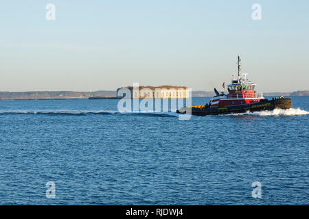Tug boat passes by Fort Gorges in South Portland, Maine USA, which is part of the New England seacoast. Stock Photo