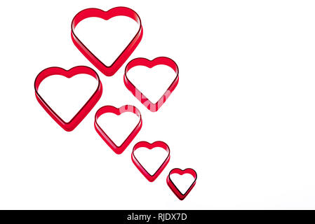 Six red heart shaped cookie cutters. Empty or broken hearted. Stock Photo