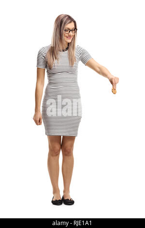 Full length portrait of a young woman holding a biscuit and looking downwards isolated on white background Stock Photo