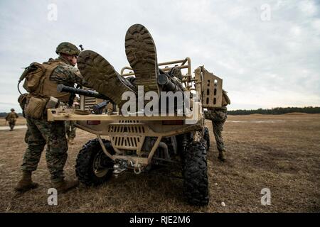 U.S. Marines and Sailors with Battalion Landing Team, 2nd Battalion, 6th Marine Regiment, 26th Marine Expeditionary Unit (MEU), load a simulated casualty onto a Utility Task Vehicle (UTV) during a live-fire platoon attack on Camp Lejeune, N.C., Jan. 17, 2018. The platoon attacks were held to improve leadership development, fire and maneuverability skills, and marksmanship for the upcoming deployment of both Marines and Sailors. Stock Photo