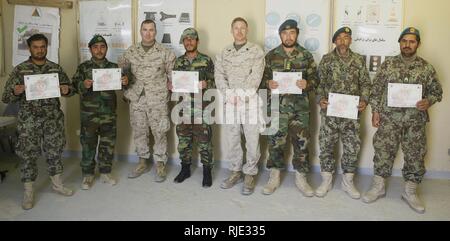 Soldiers of the Afghan National Army 215th Corps show off their graduation certificates from the Tactical Site Exploitation Course while standing alongside Marines who helped evaluate and refine the soldiers skills of at Camp Shorabak, Afghanistan, Jan. 18, 2018. The course teaches follow-on skills and progressive training of explosive ordnance disposal lead by Task Force Southwest. The graduates are now certified to train other soldiers in the same course, thus helping to self-sustain the 215th Corps. Stock Photo