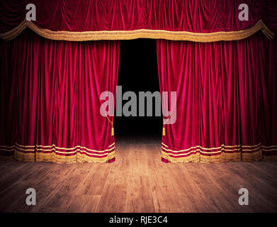 The red curtains are opening for the theater show Stock Photo
