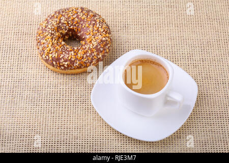 Coffee break with fresh donuts over textile background. Stock Photo