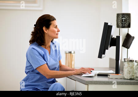Female doctor using a computer inside a doctor's office. Stock Photo