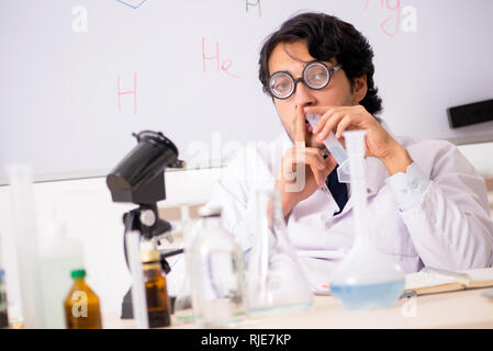 Young funny chemist in front of white board Stock Photo