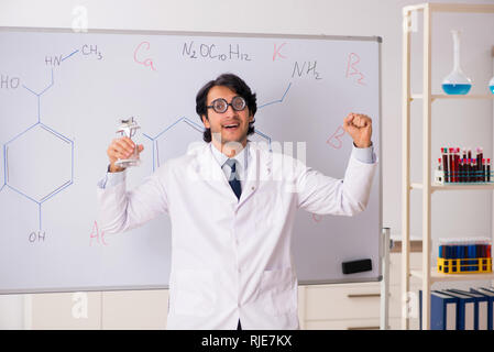 Young funny chemist in front of white board Stock Photo