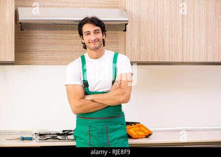 Young contractor repairing oven in kitchen Stock Photo