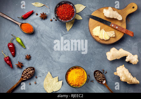 Various Spices powder turmeric, chili, bayberry, bay leaf, ginger on cutting board, cinnamon, cumin, star anise on grey stone background with space fo Stock Photo