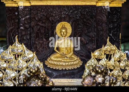 Wood Carving of Gilded Buddha under Bodhi tree at Wat Phra Kaeo - Chiang Rai, Thailand Stock Photo