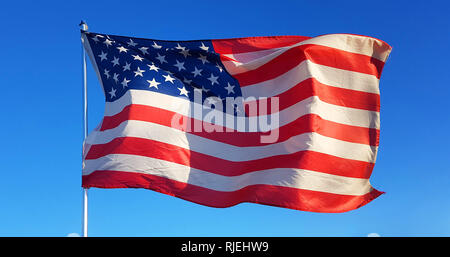 on Thanksgiving Day the flag of the United States of America flies with the wind of freedom in the blue sky and defends all American citizens Stock Photo