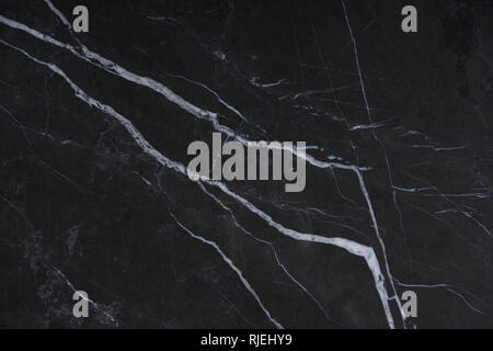 Natural stone Italian marble with white stripes on a dark background, called Nero Marquina. Stock Photo