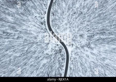 Beautiful winter forest road seen from above. Aerial drone shot Stock Photo