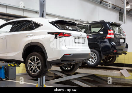 Russia, Izhevsk - October 20, 2018: Repair and check cars in the automobile workshop. Using a hydraulic lift. Modern service. Stock Photo