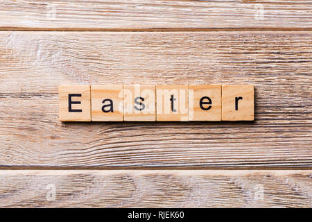 Easter word written on wood block. Easter text on wooden table for your desing, concept. Stock Photo