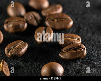 Focus on a single coffee bean on a background of many grains of coffee Stock Photo