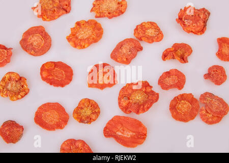 Dried carrots chips (slices) on white background. Flat lay. Stock Photo