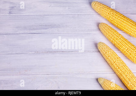 Fresh yellow corn on the cob kernels on a white wooden background. Fresh vegetables. Stock Photo