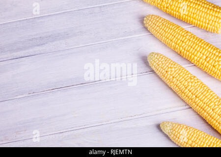 Fresh yellow corn on the cob kernels on a white wooden background. Fresh vegetables. Stock Photo