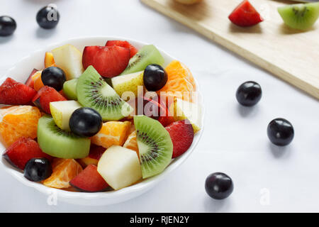 Fresh salad from kiwi, oranges, plums and other fruits. Healthy lifestyle. Vegetarian food. Stock Photo