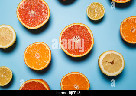 cut in half juicy citruses on a blue background.  Fresh summer concept with tropical fruits. popular pattern Stock Photo