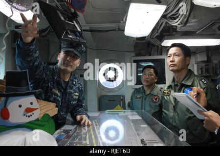 YOKOSUKA, Japan (Nov. 27, 2012) Lt. Cmdr. James Stockman, public affairs officer aboard the aircraft carrier USS George Washington (CVN 73), explains the ouija board in flight deck control to Republic of Korea navy Rear Adm. Jae-Ok Shim, commander of Air Wing 6, during a tour of the ship. George Washington and embarked Carrier Air Wing (CVW) 5 provide a combat-ready force that protects and defends the collective maritime interests of the U.S. and its allies and partners in the Asia-Pacific region. Stock Photo