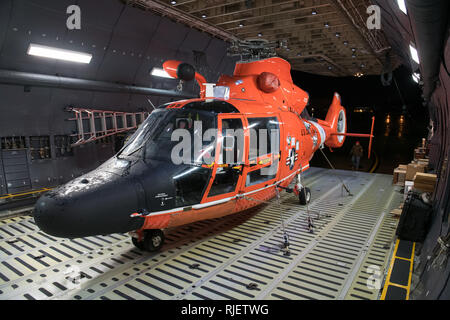 A Coast Guard Air Station San Fransisco MH-65D Dolphin helicopter sits inside a C5-M Super Galaxy after its load completion at Travis Air Force Base, California, Feb. 2, 2019. The helicopter was transferred to another Coast Guard air station in the Pacific area of command. (U.S. Air Force photo by Lan Kim) Stock Photo