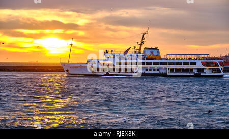 Passenger ferry as it enters the port of Kadikoy at sunset, on the asian side of Istanbul, Turkey Stock Photo